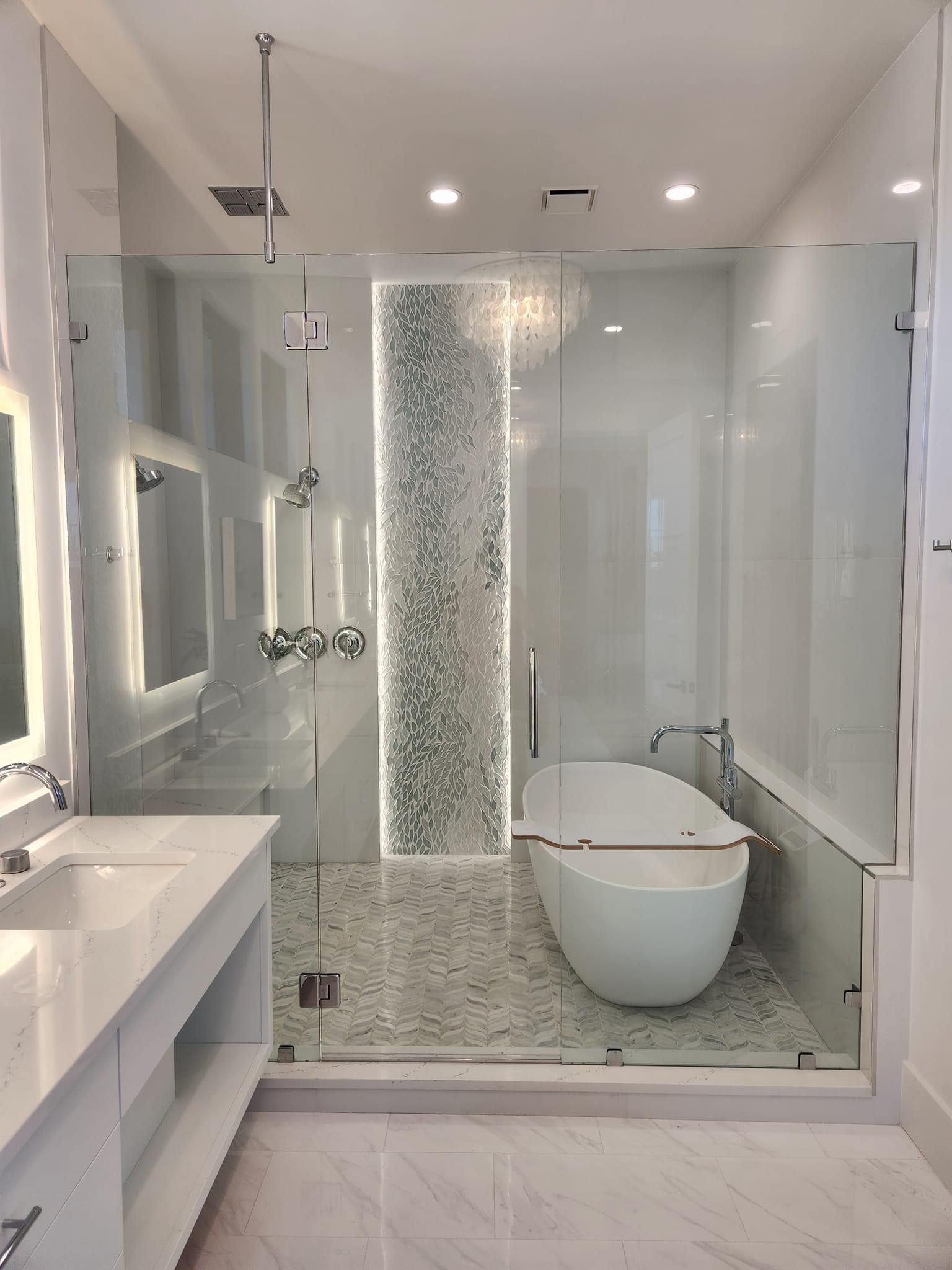 A bathroom with green cabinets , two sinks , a shower and two mirrors.