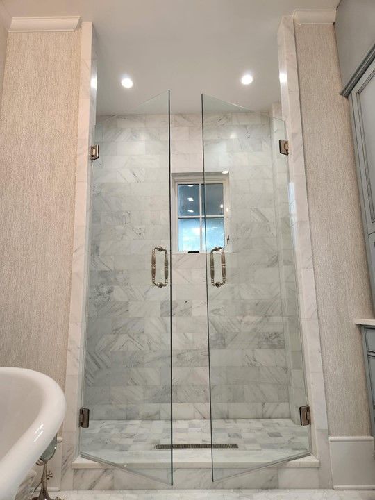 A bathroom with a walk in shower and a bathtub.