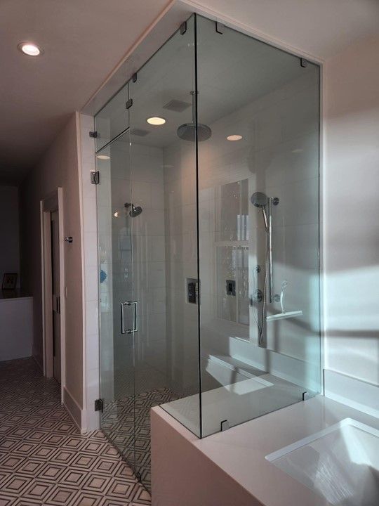 A bathroom with a walk in shower and a sink.