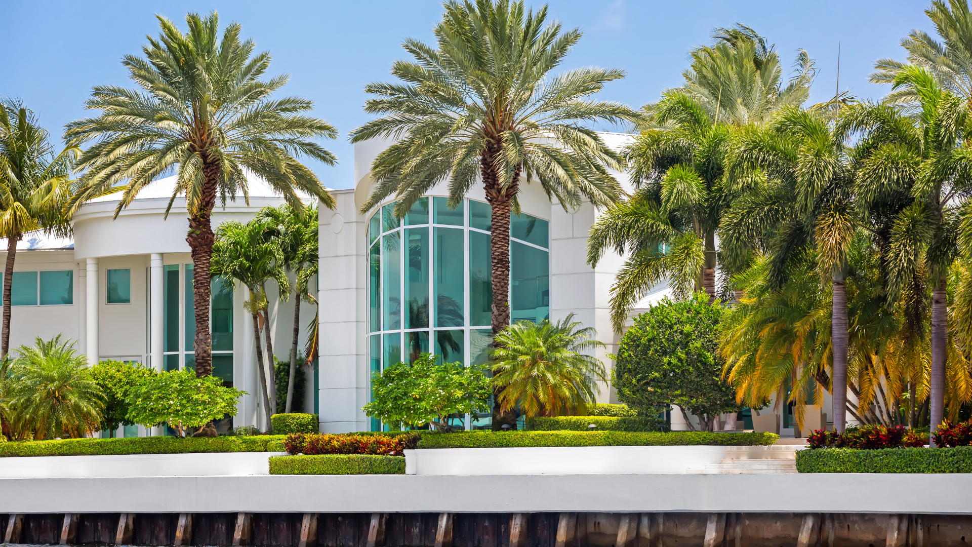A large white house with palm trees in front of it.