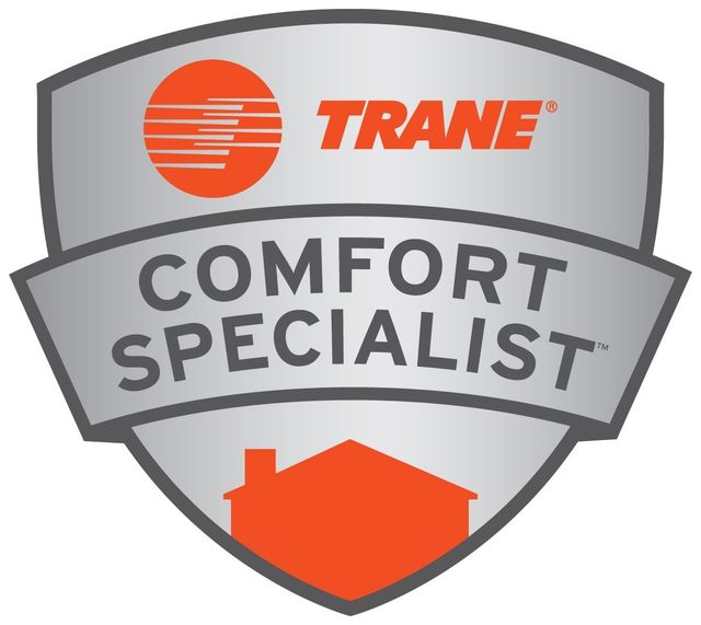 Silver shield logo with the orange Trane logo, the text "COMFORT SPECIALIST," and an orange house silhouette at the bottom.