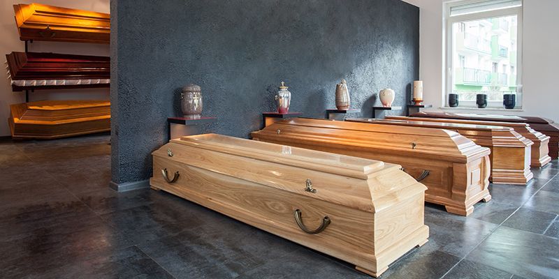 A row of wooden coffins are lined up in a room.