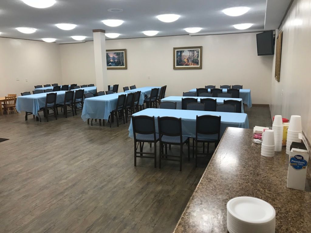 A large room with tables and chairs set up for a party.