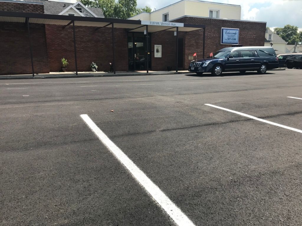 A parking lot with cars parked in front of a building