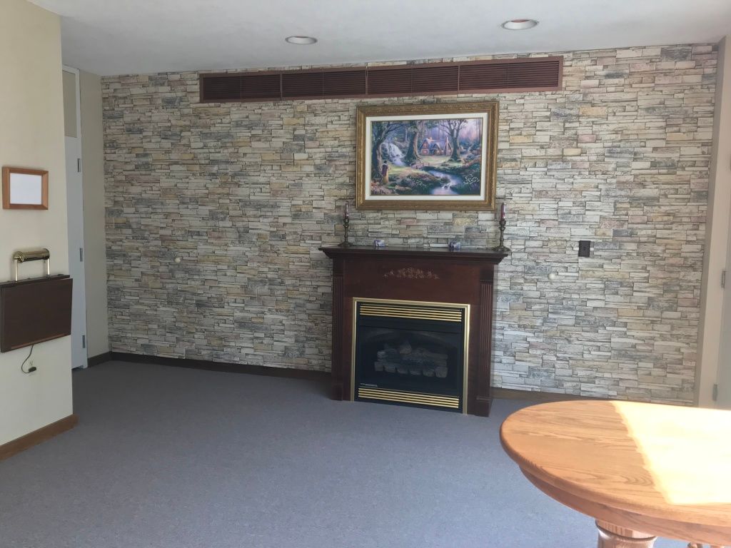A living room with a fireplace and a painting on the wall