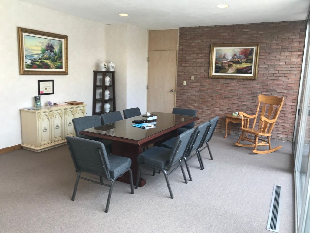A conference room with a table and chairs and a rocking chair.