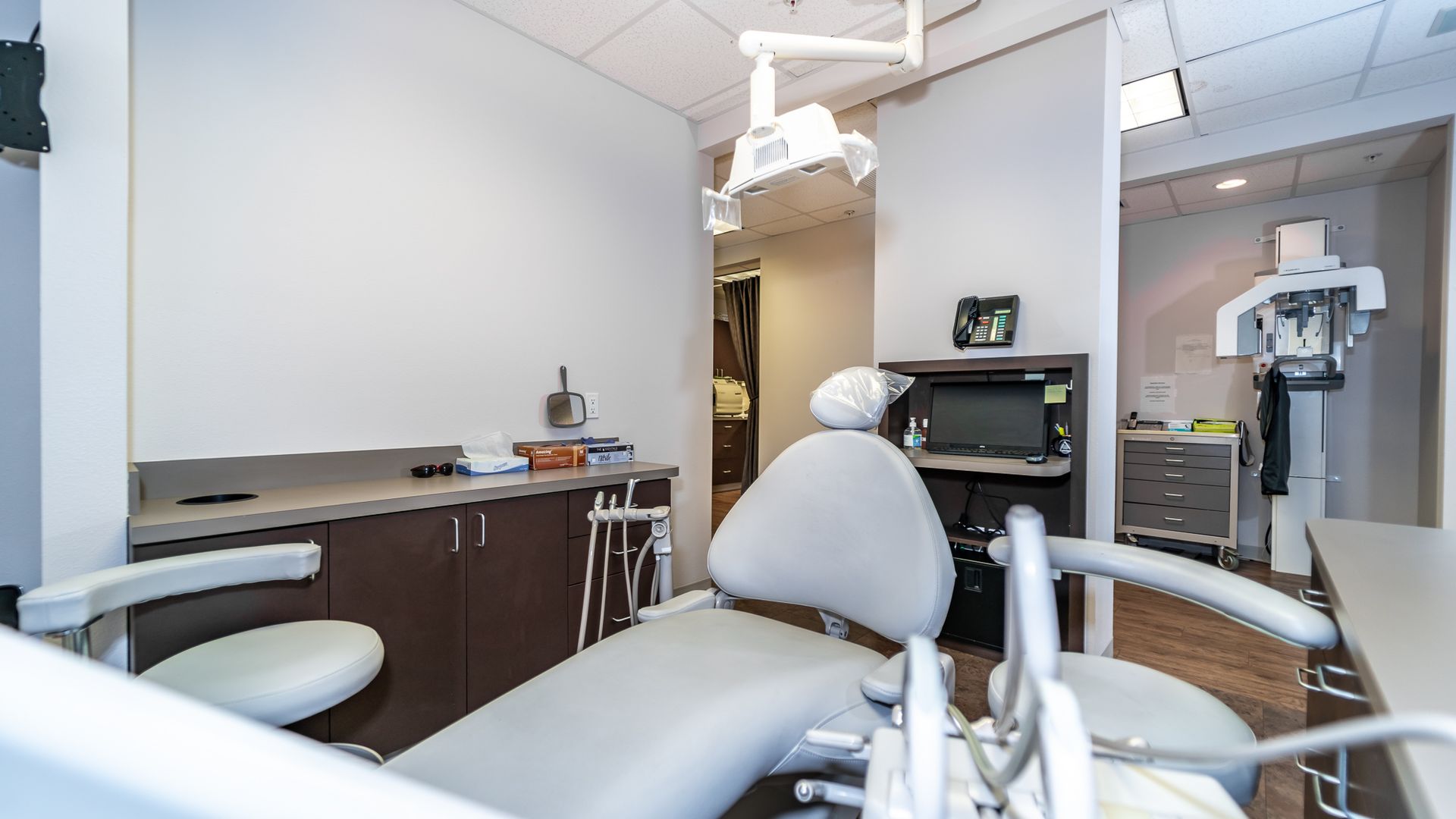A dental office with a dental chair and a x-ray machine