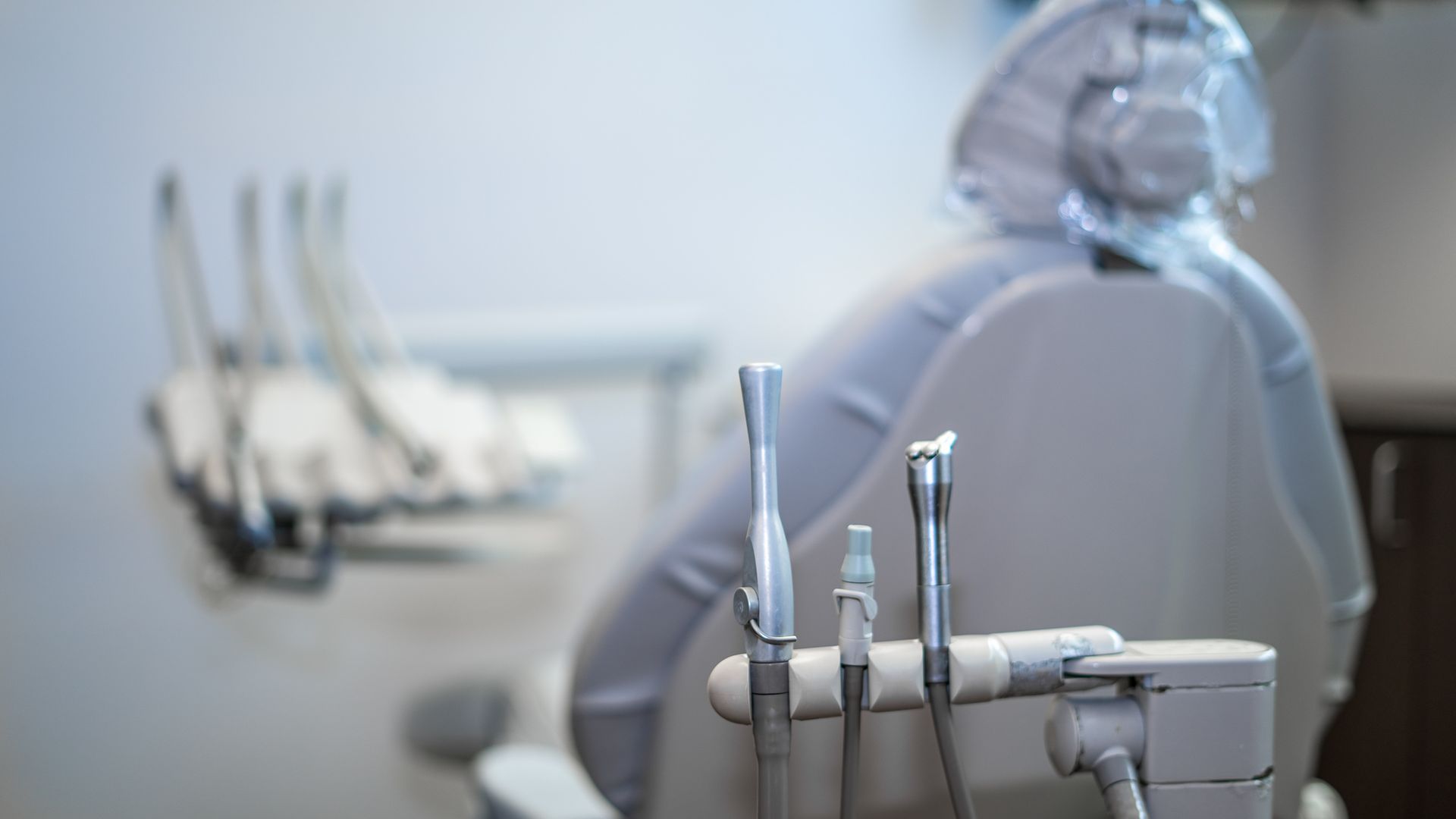 A close up of a dental chair with dental instruments in a dental office.