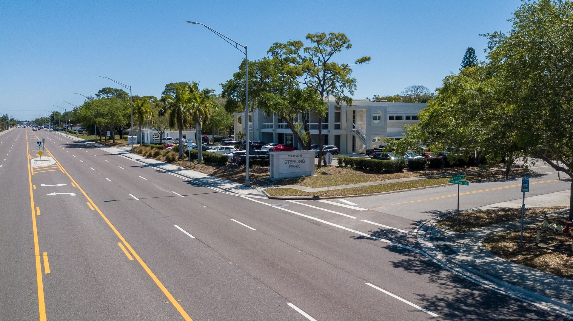 An aerial view of a street with trees on both sides