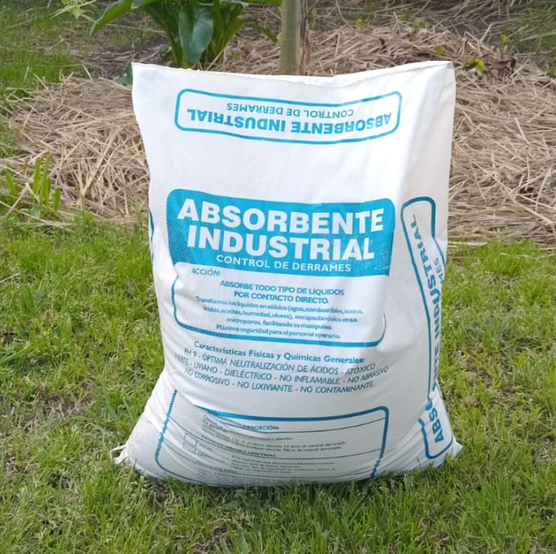 Bolsa blanca etiquetada "Absorbente Industrial" sobre césped, utilizada para controlar derrames.