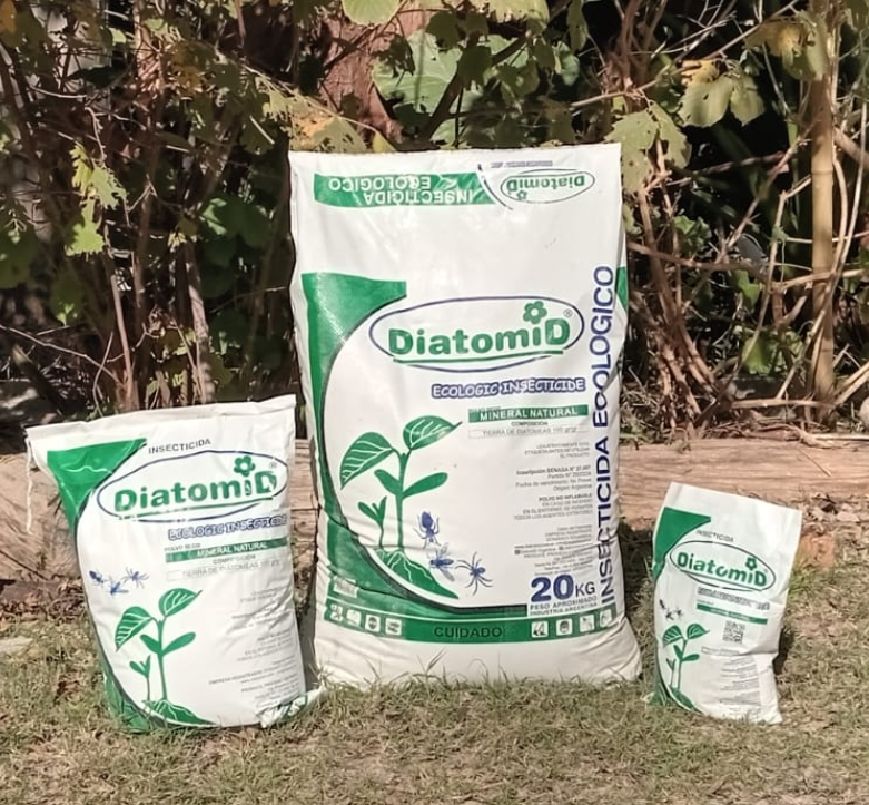 Tres bolsas de insecticida DiatomiD sobre césped. Bolsas blancas con detalles verdes, plantas.