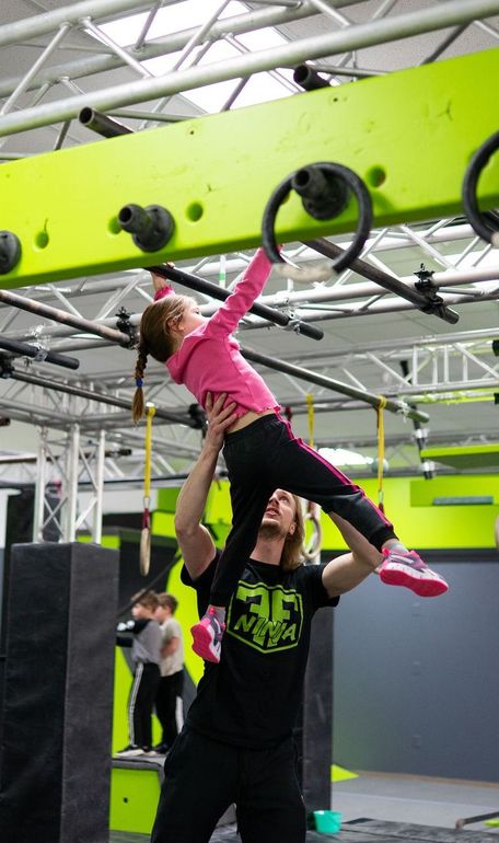A pair of gymnastic rings hanging from a rope in a gym.
