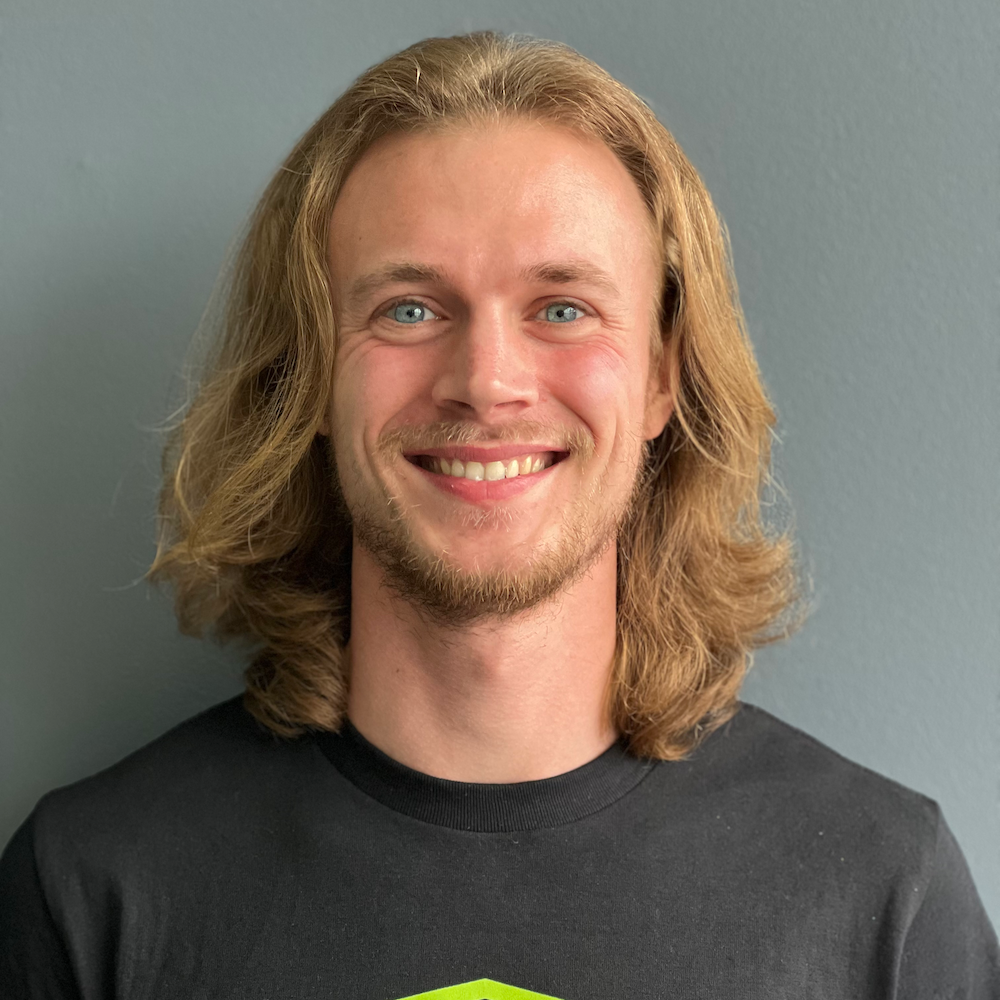A man with long blonde hair and a beard is smiling for the camera.