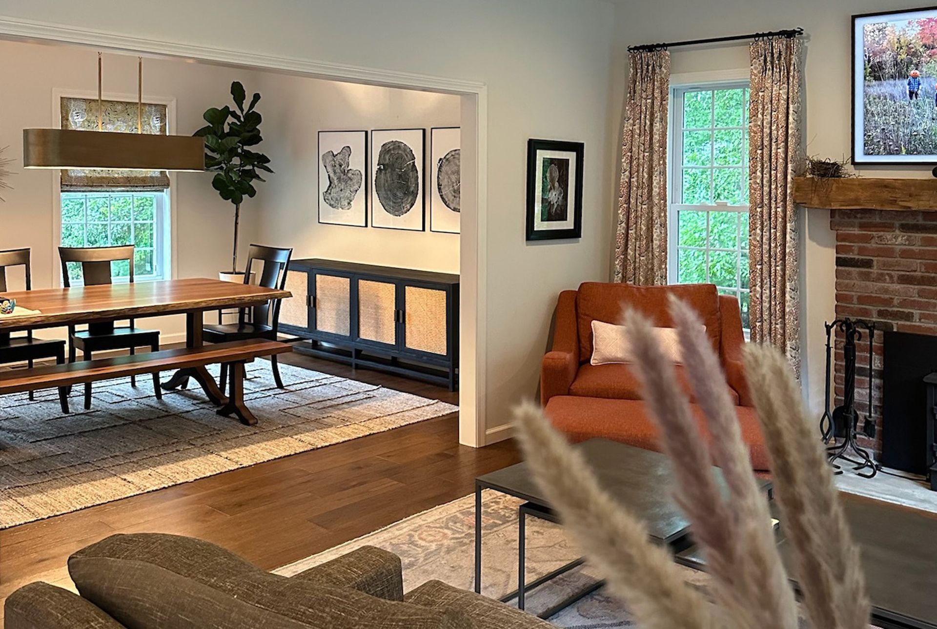 Living room with dining area, brick fireplace, and orange chaise lounge.