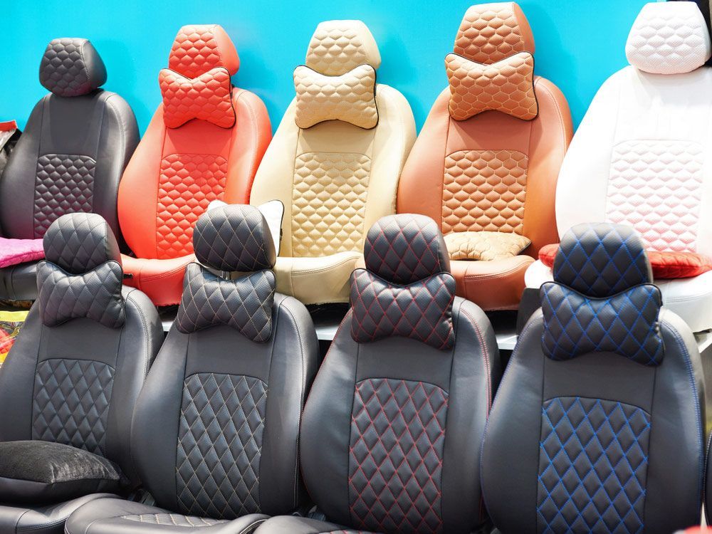 A Row Of Car Seat Covers With Neck Pillows On Display In A Store — Gaeta's Upholstery Blinds & Awnings in Glen Innes, NSW