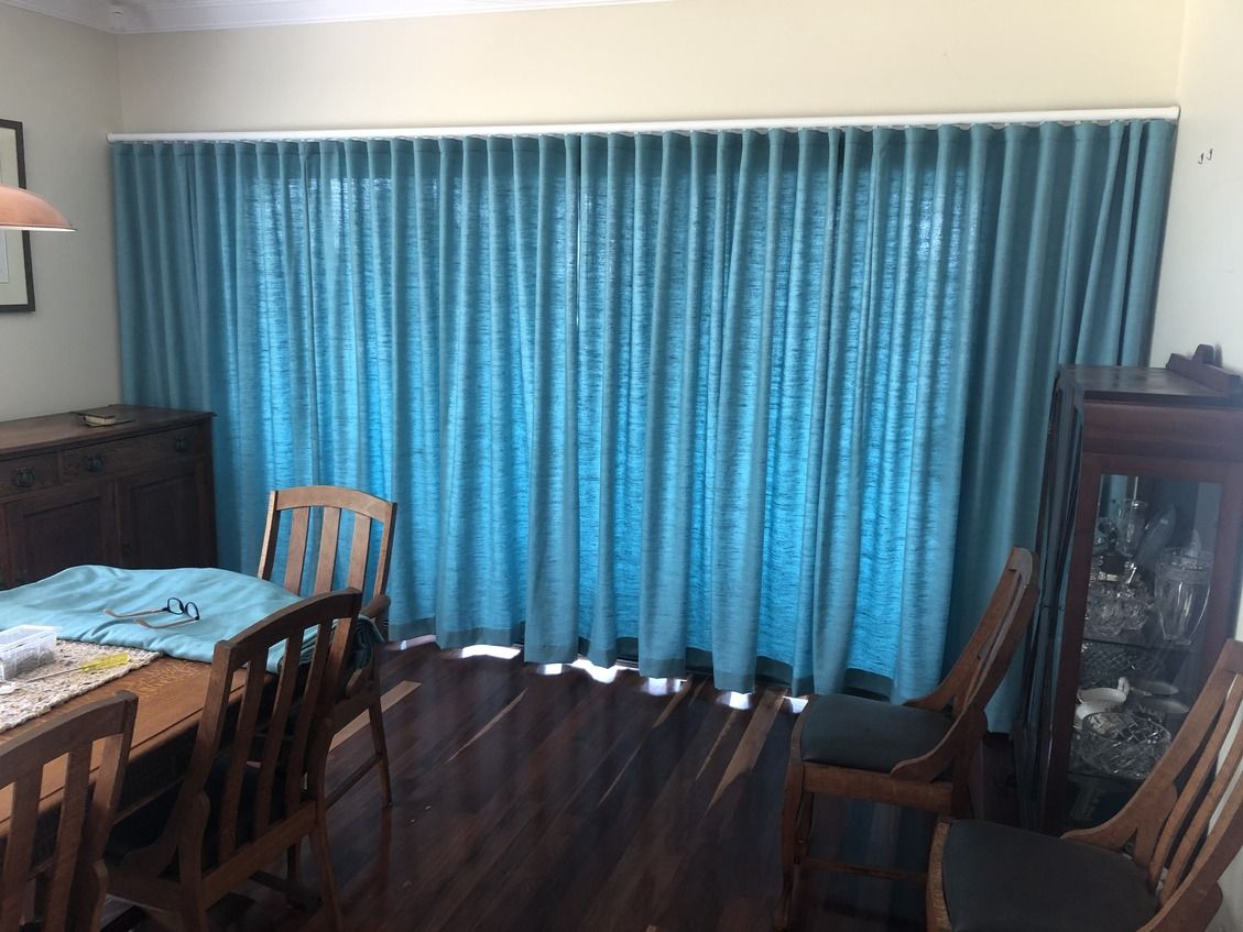 A Living Room With A Sliding Glass Door And Yellow Curtains — Gaeta's Upholstery Blinds & Awnings in Grafton, NSW