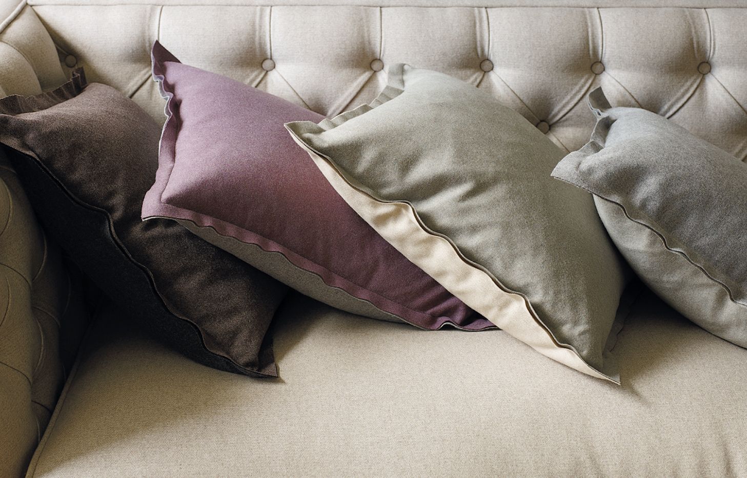 A Person Is Working On A Tufted Leather Couch — Gaeta's Upholstery Blinds & Awnings in Grafton, NSW