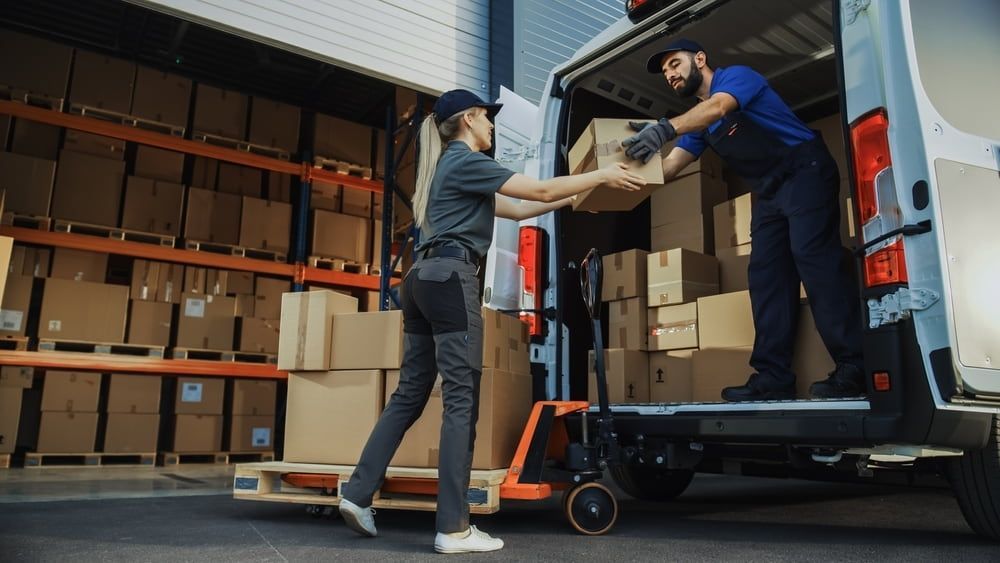 A Delivery Worker Hands a Box to a Colleague — Cairns Mini Movers In Mount Sheridan, QLD