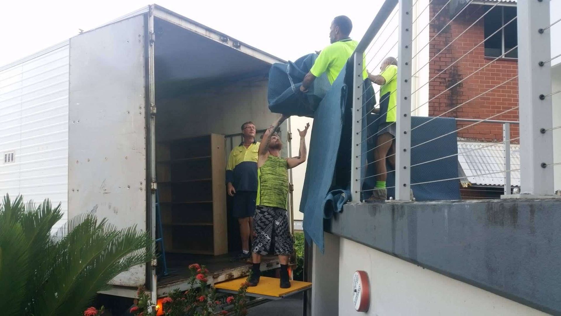 Three Men Are Unloading Furniture — Cairns Mini Movers In Mount Sheridan, QLD