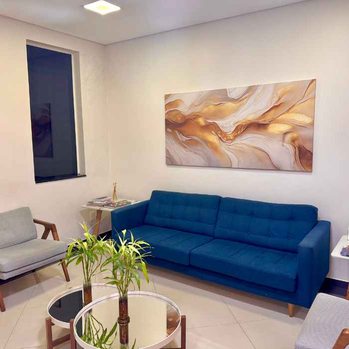 Uma sala de estar com um sofá azul e uma pintura na parede