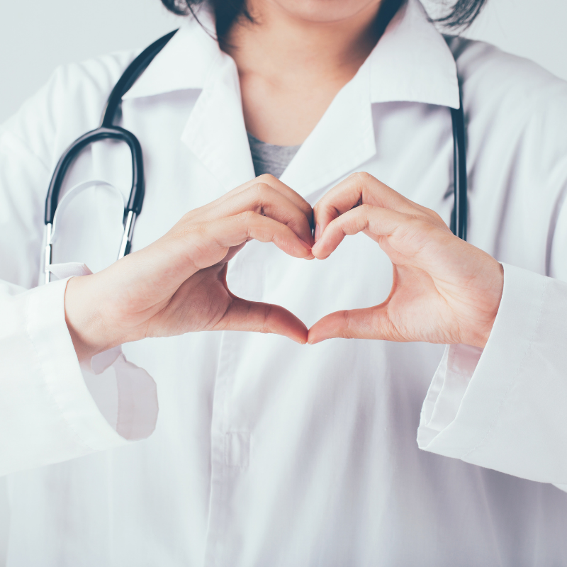 Uma médica fazendo um formato de coração com as mãos