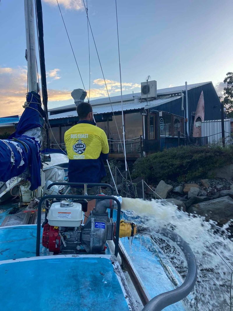 Man using high-pressure water blasting machine on boat