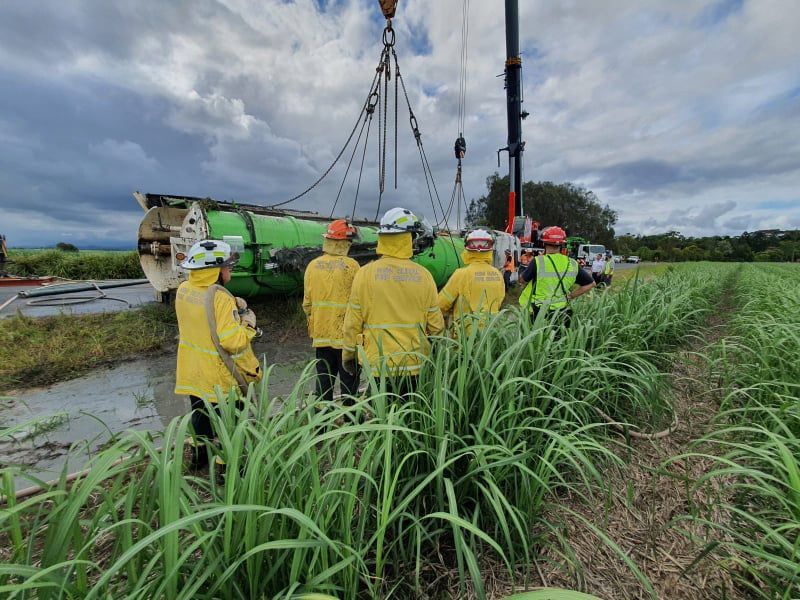 People using crane to lift truck from water