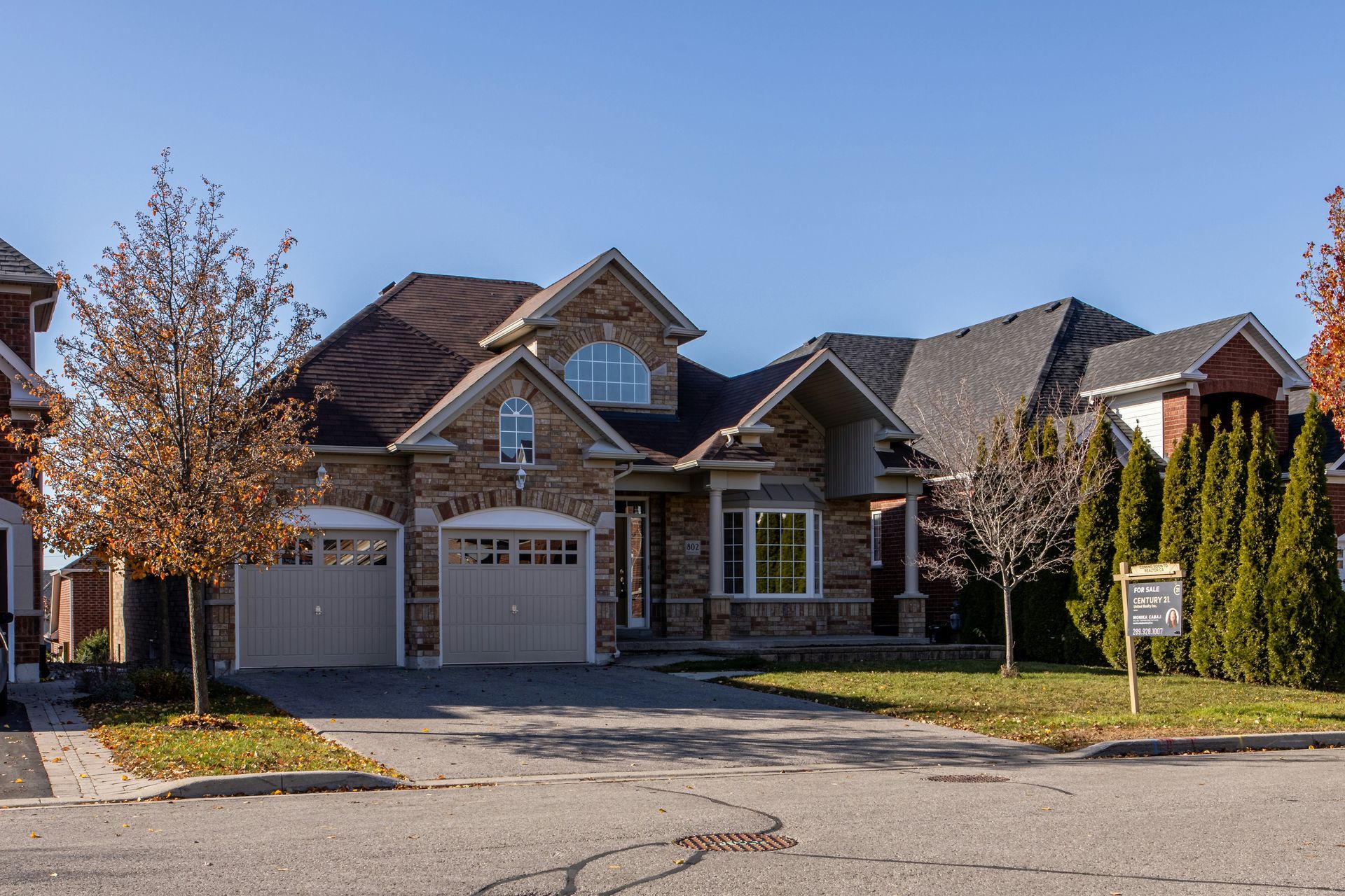 A large house with two garages is for sale in a residential area.