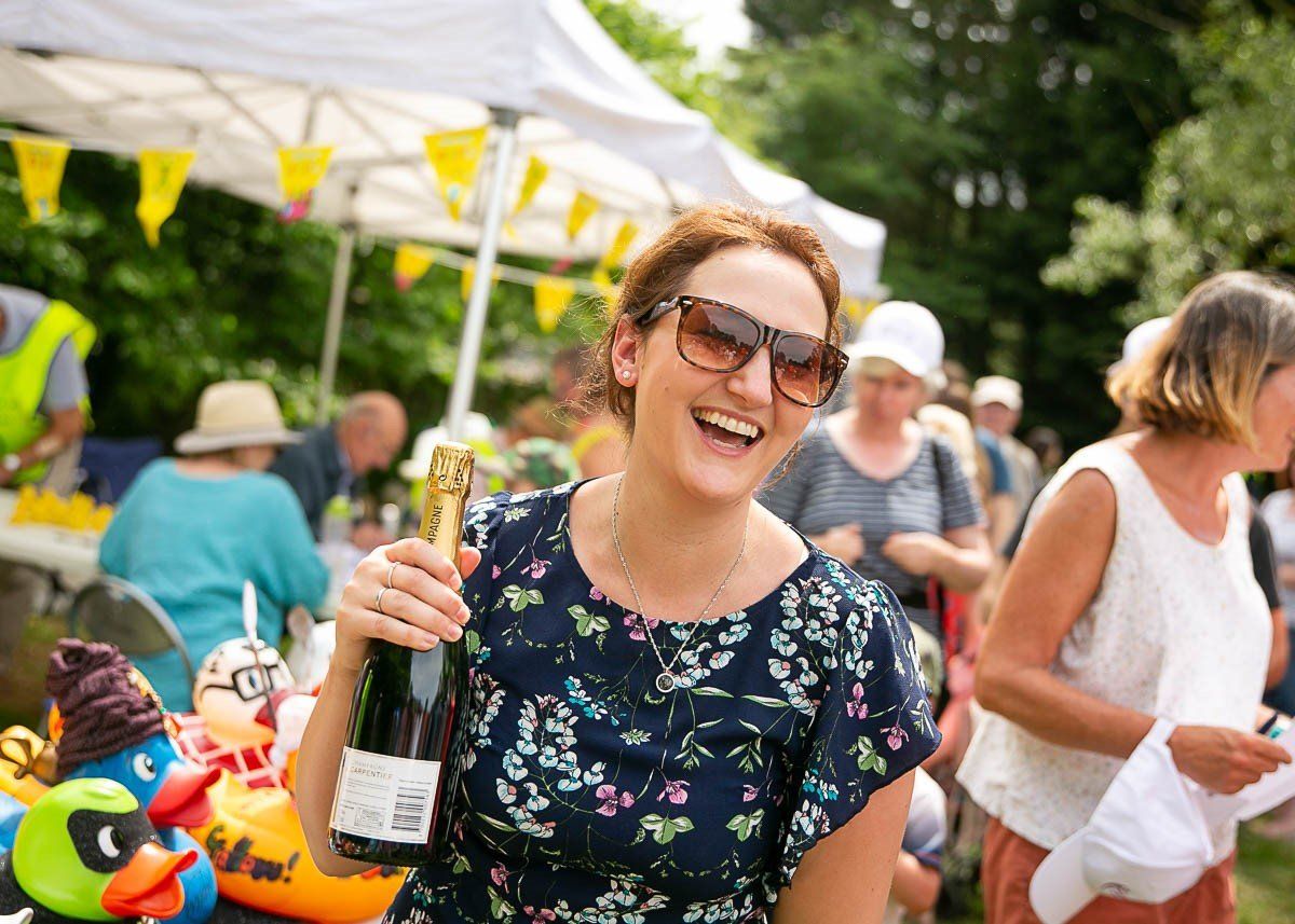 Woman holding bottle of fizz at Fakenham Duck Race