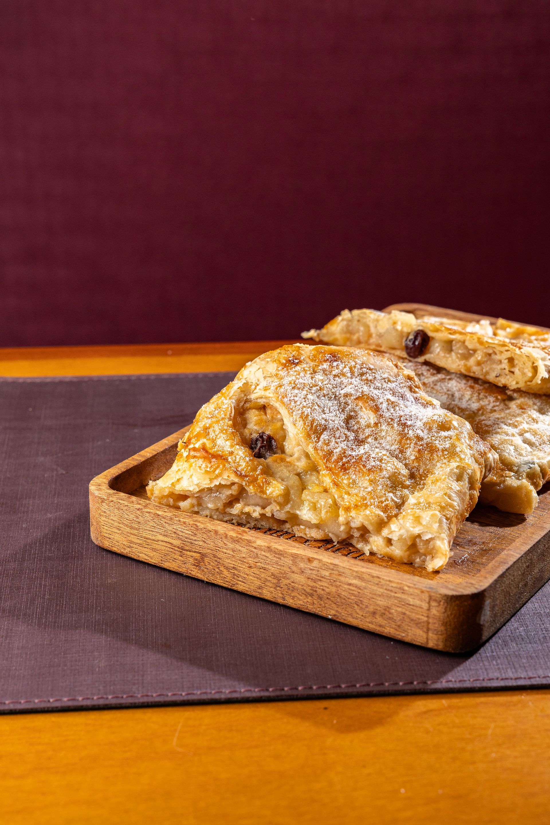 Uma bandeja de madeira cheia de doces sobre uma mesa.