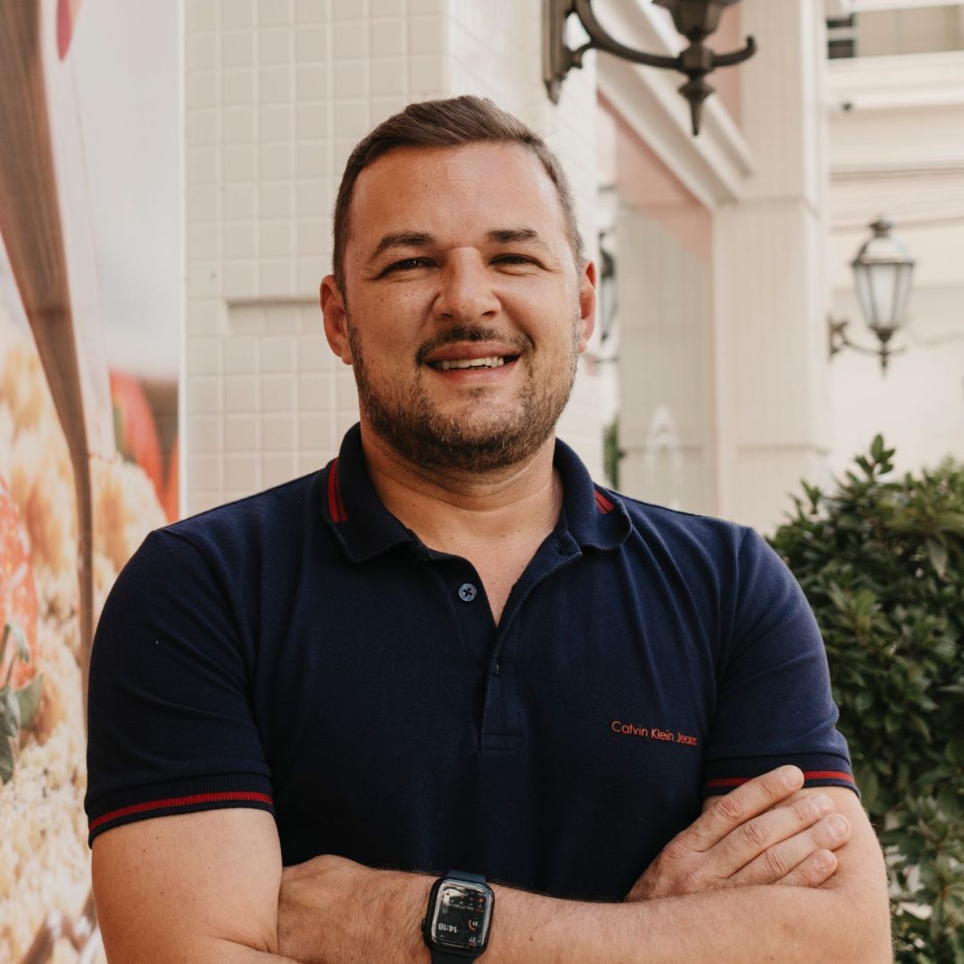 Um homem com os braços cruzados está usando um relógio