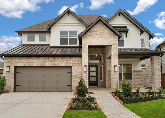 A large brick house with a brown garage door