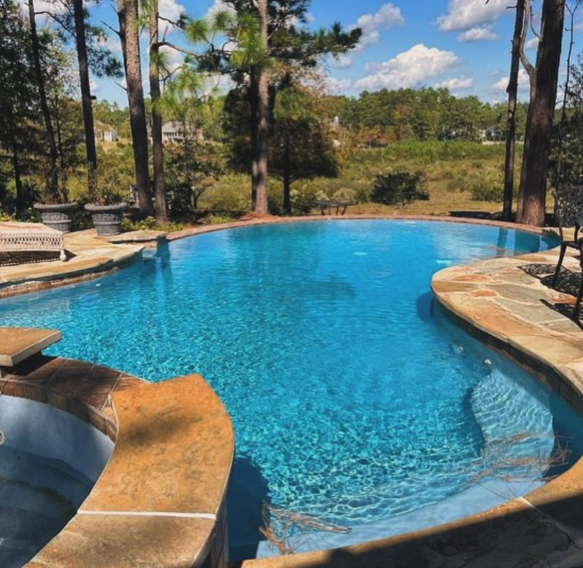 A large inground swimming pool and spa with water features installed by Caroline Pool Plastering in Huntsville, NC