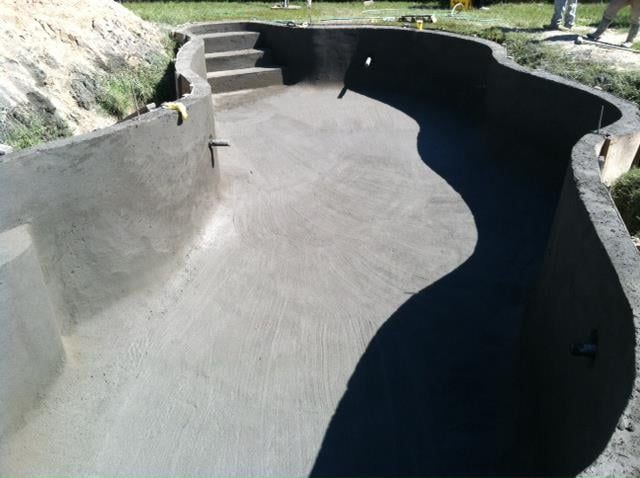 A swimming pool is being built in a backyard by Caroline Pool Plastering in Charlotte, NC