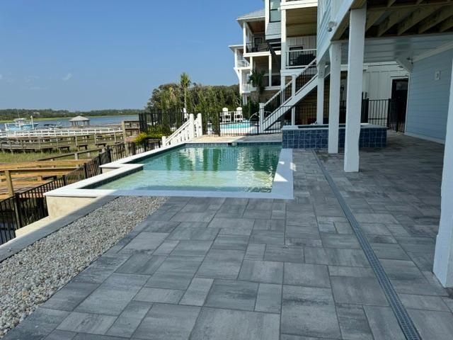 A large house with a swimming pool in front of it installed by Caroline Pool Plastering in Huntsville, NC