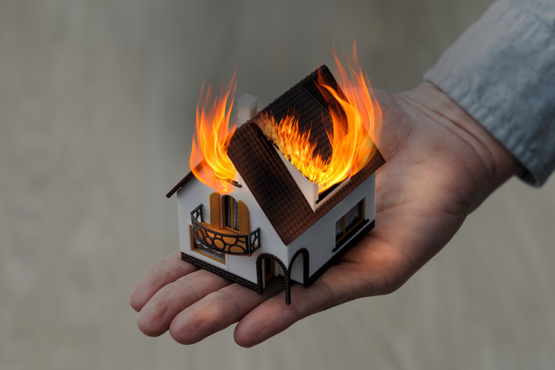 Conceptual image of a hand holding a burning house | Cumberland County NJ