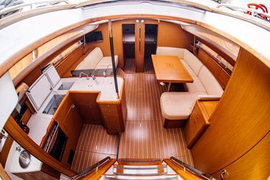 Aerial view of the internal living quarters of a boat with custom wood table and fitted with teak interior