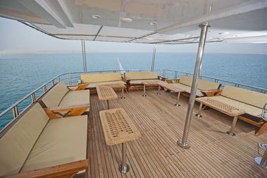 The lower level of a yacht stern with teak decking and custom yacht furniture