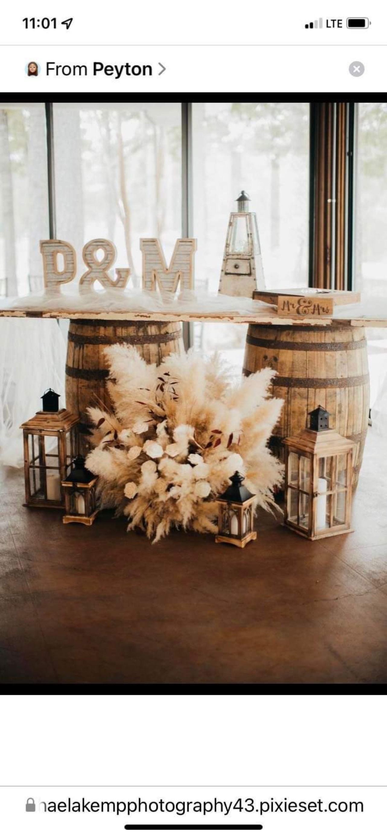Rustic wedding decor with “P&M” letters, dried flowers, and lanterns by a window