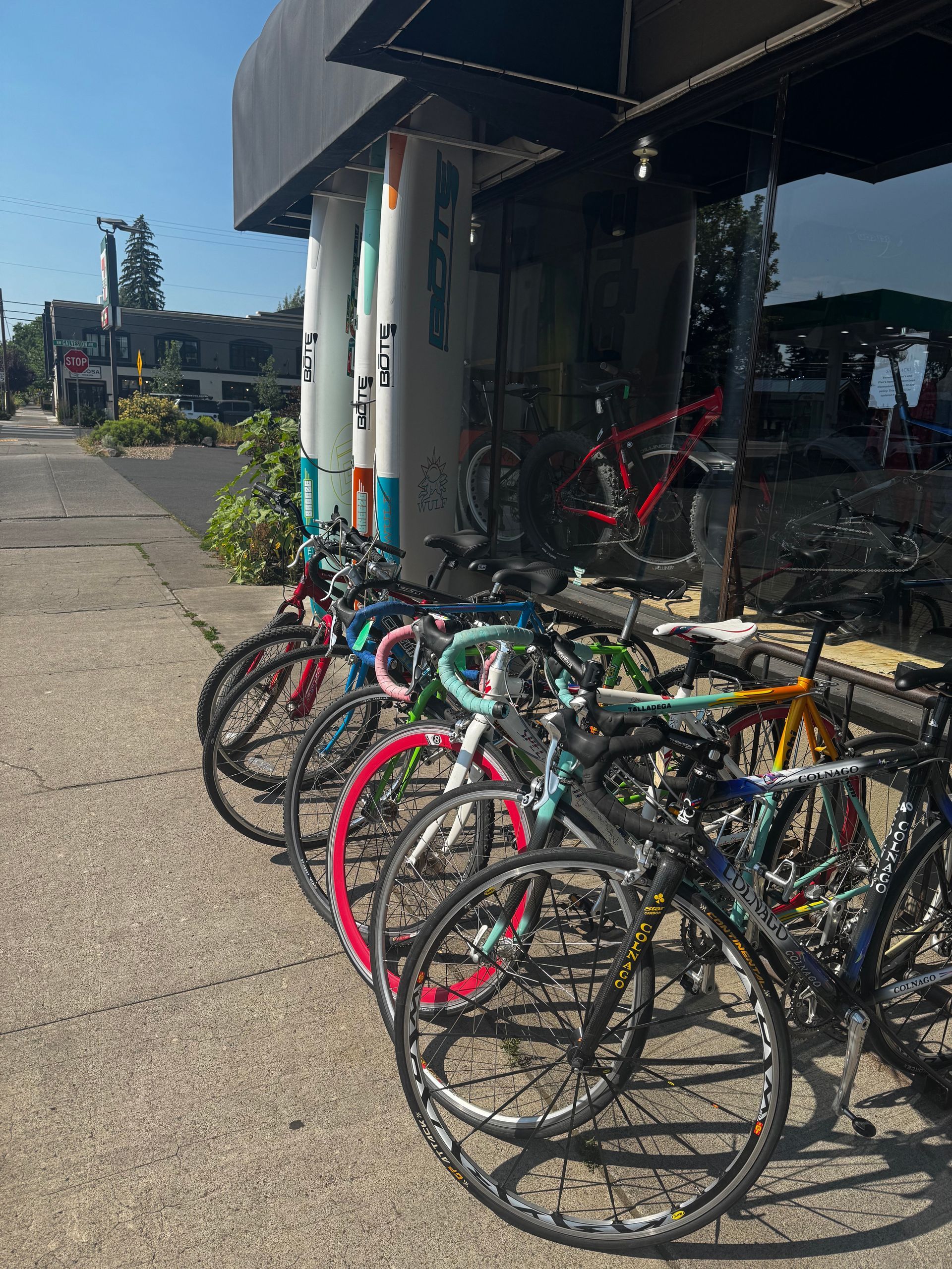 A row of bicycles are parked outside of a store