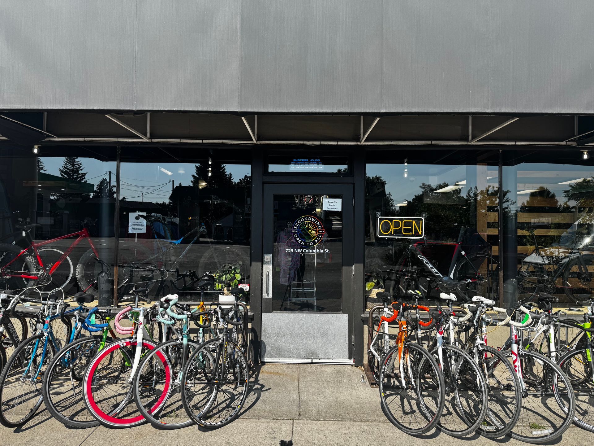 A row of bicycles are parked in front of a store.