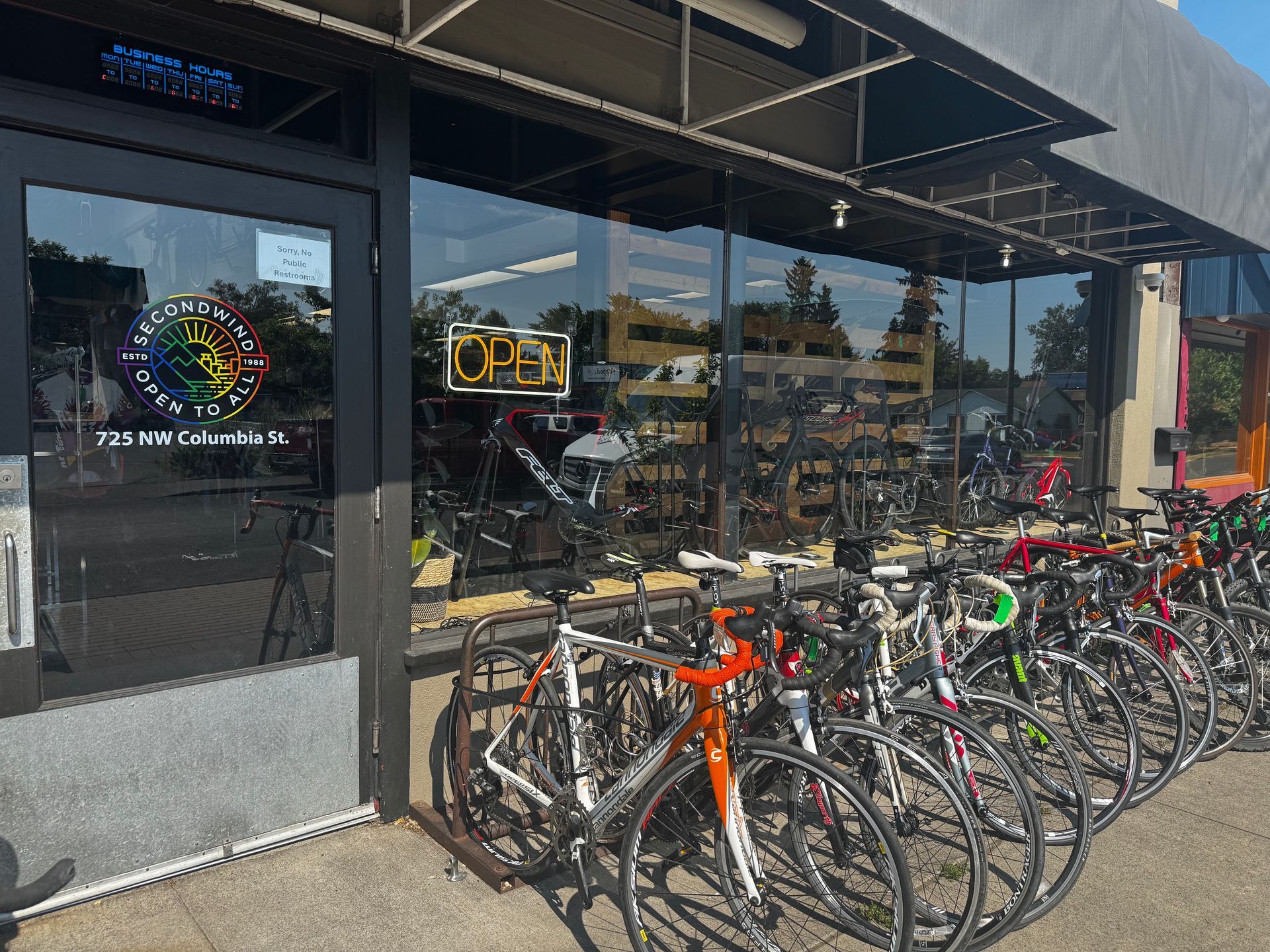 Outdoor gear consignment shop with mural, paddleboards, and bicycles.