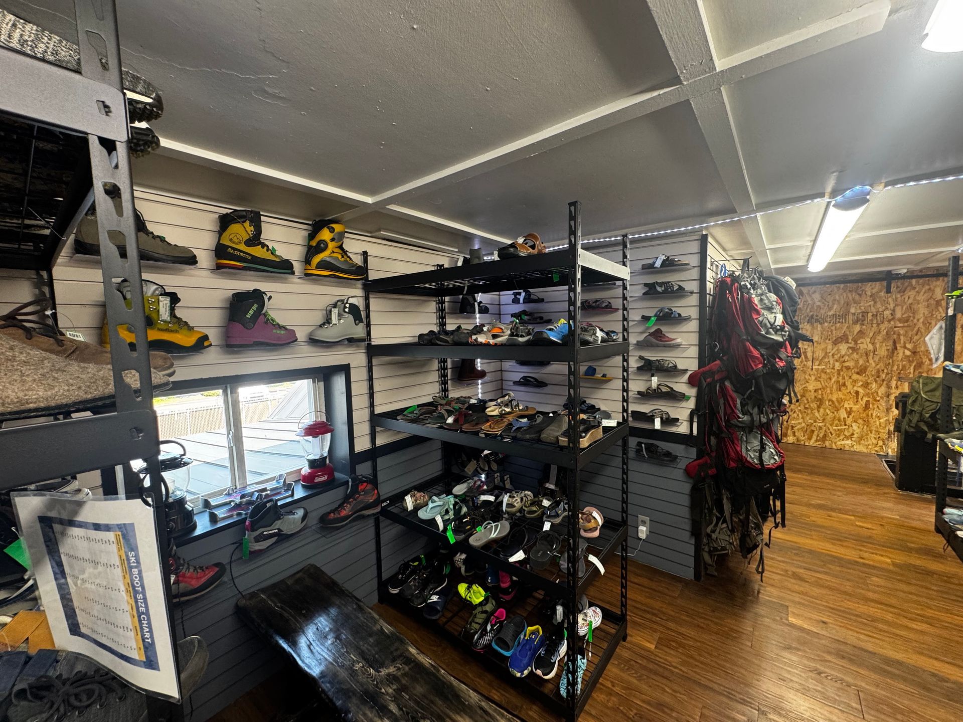Inside a gear shop: shelves with shoes and backpacks and hiking boots