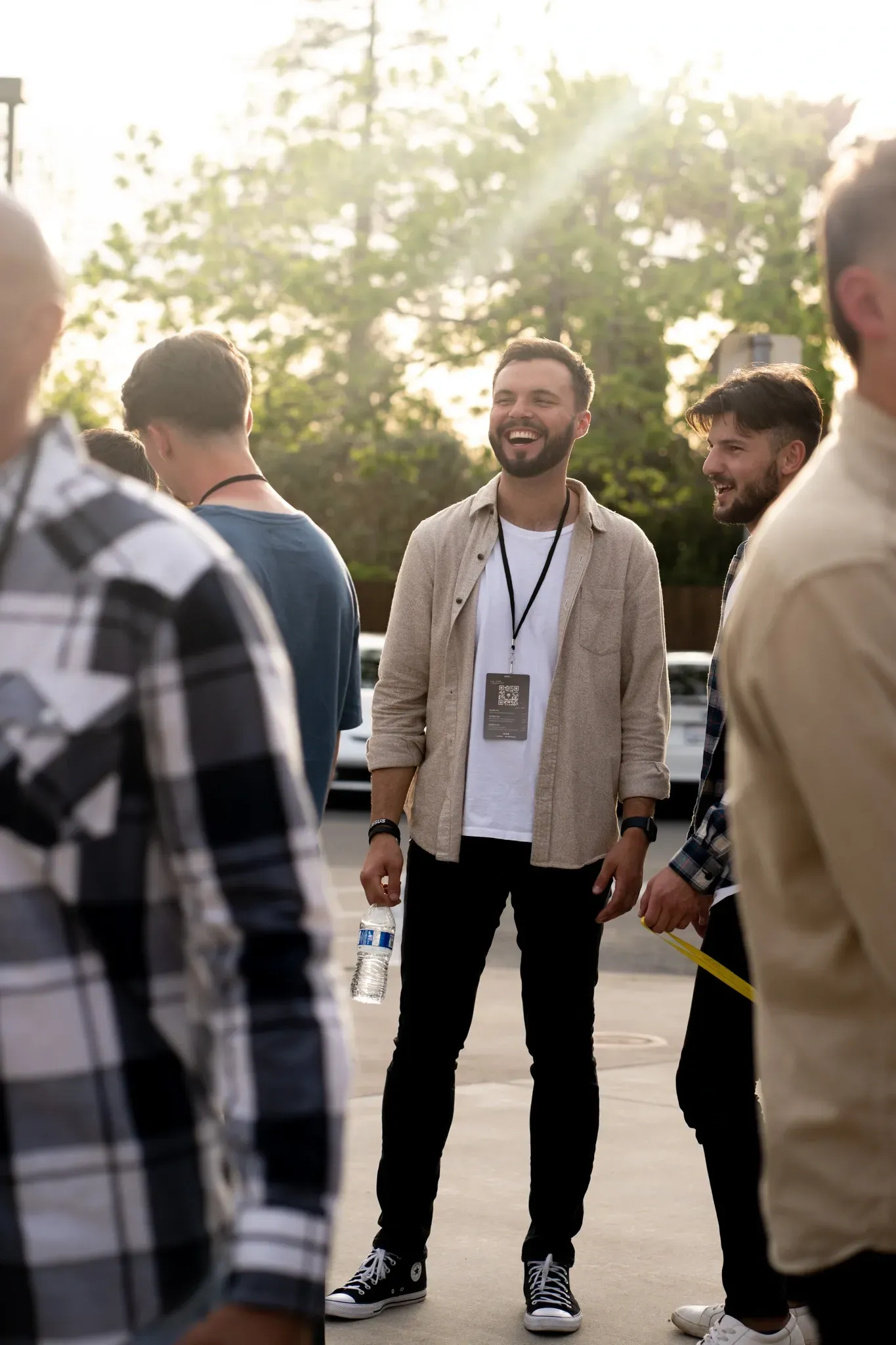 A man with a lanyard around his neck is standing in a crowd of people.