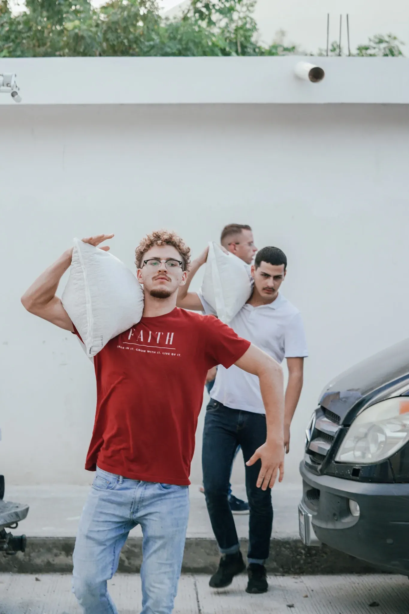 A man is carrying a bag of rice on his shoulder.