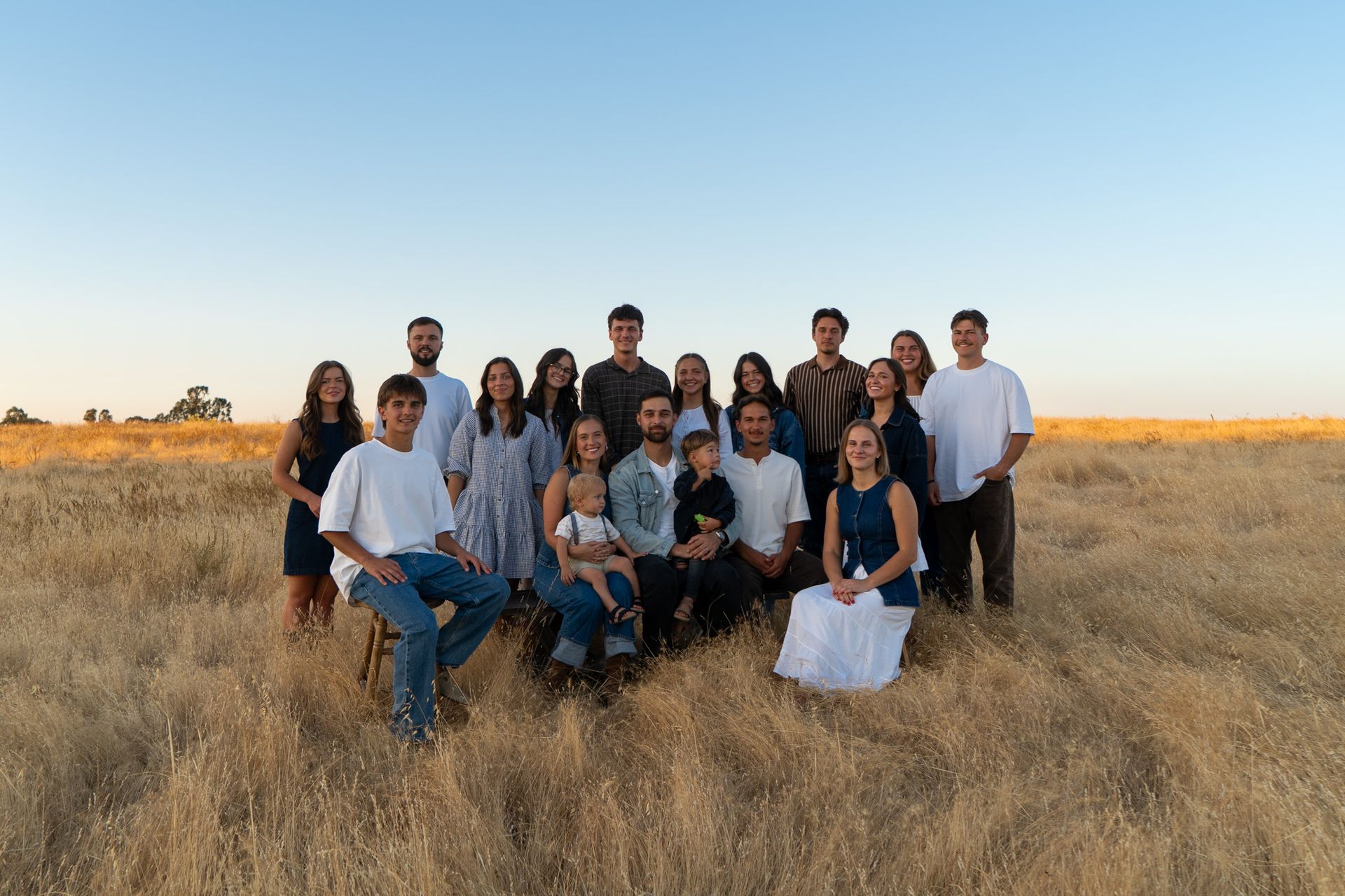 A large group of people are posing for a picture in a field.