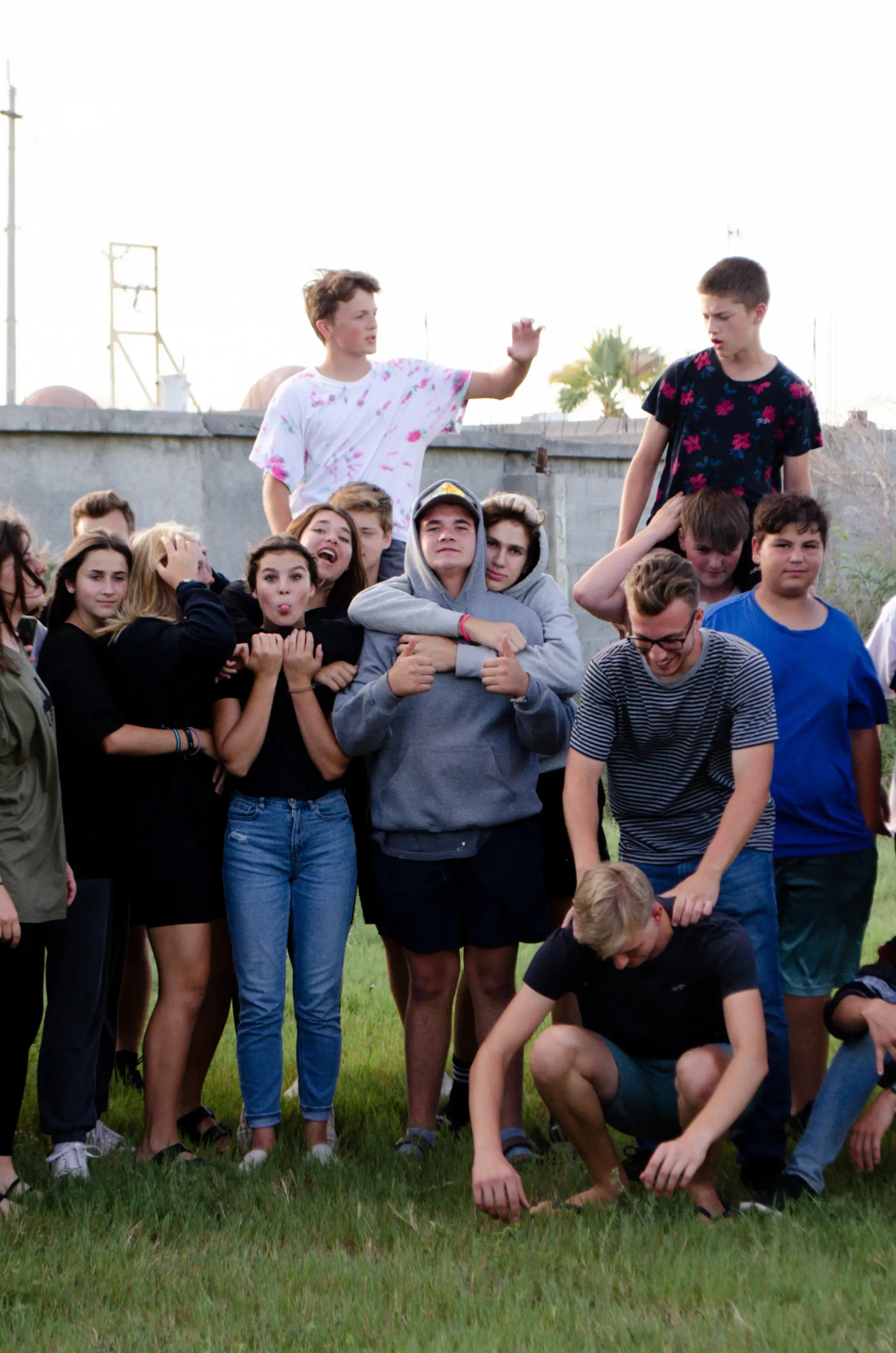 A group of young people are posing for a picture in the grass.