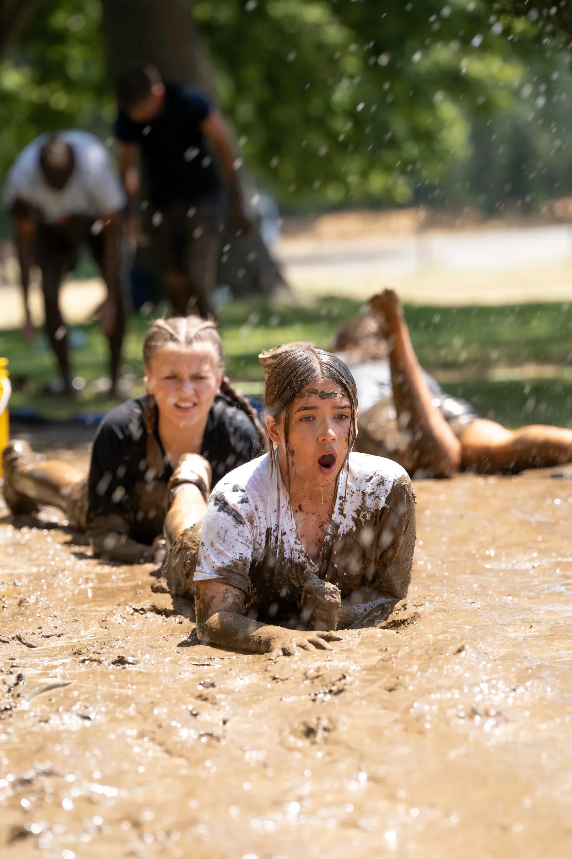 A group of people are laying in the mud.