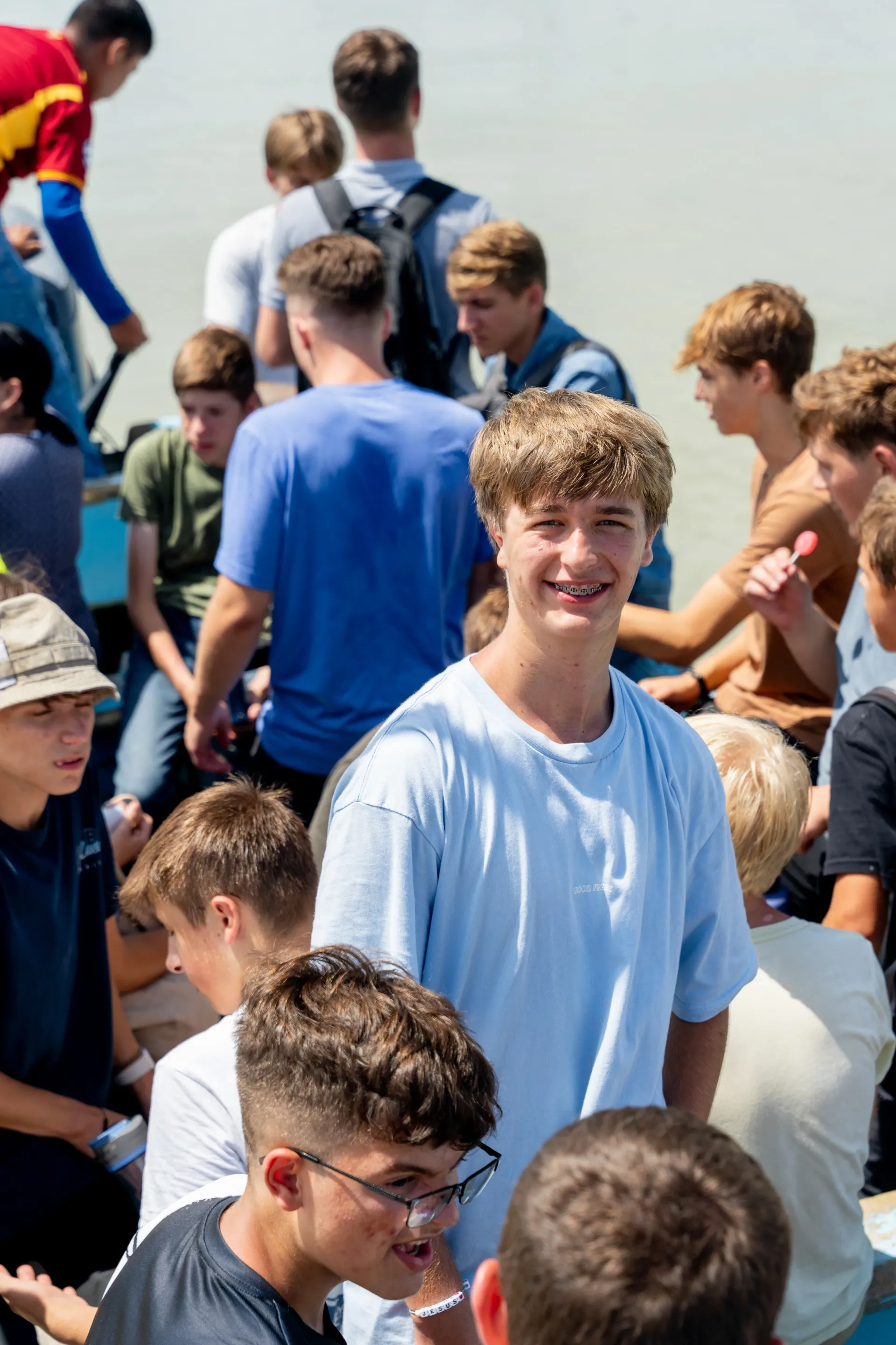 A group of young men are standing in a line on a beach.