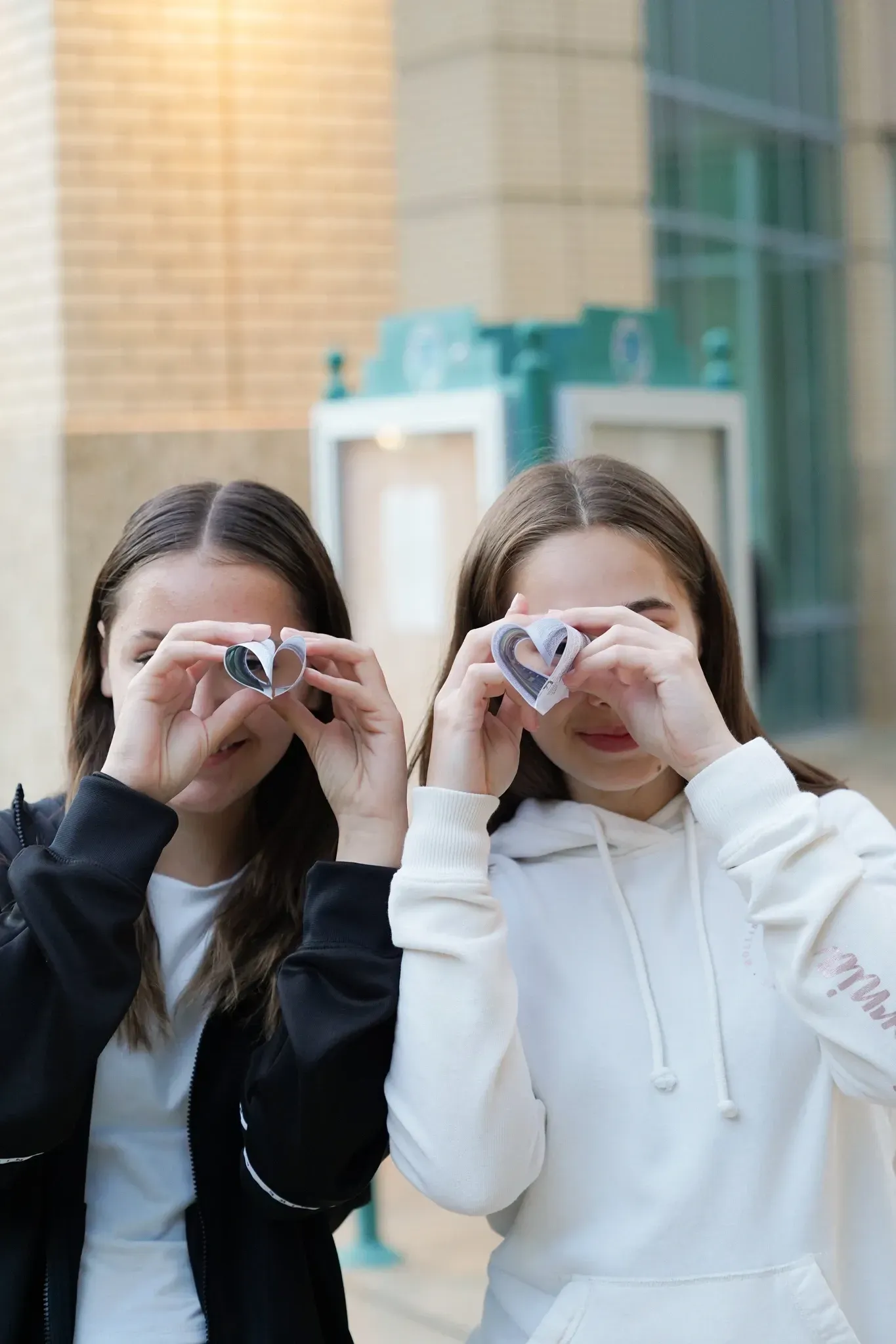 Two girls are taking a picture of each other with a camera.